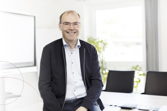 Frank Hansen sitzt auf einem Tisch