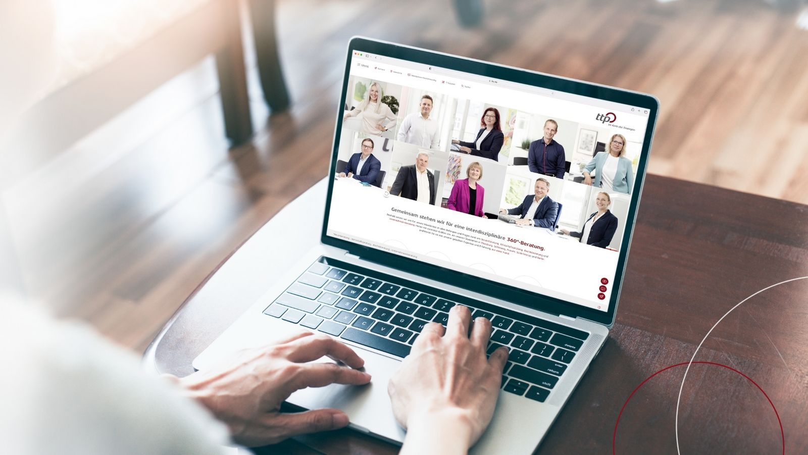 Blick über die Schulter auf einen Laptop, der die Website von ttp mit Mitarbeiterbildern zeigt