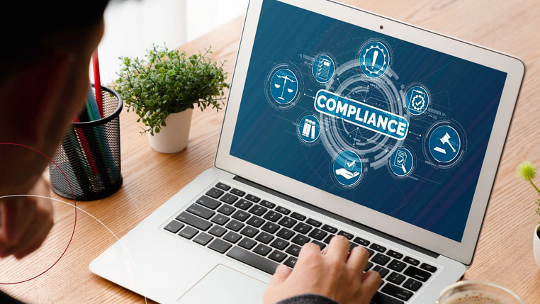 Aufgeklapptes Notebook zeigt Compliance-Grafik