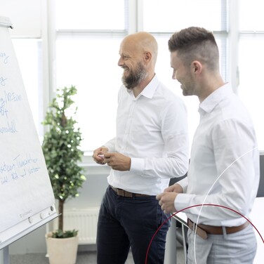 Zwei ttpler stehen vor einer weißen Tafel