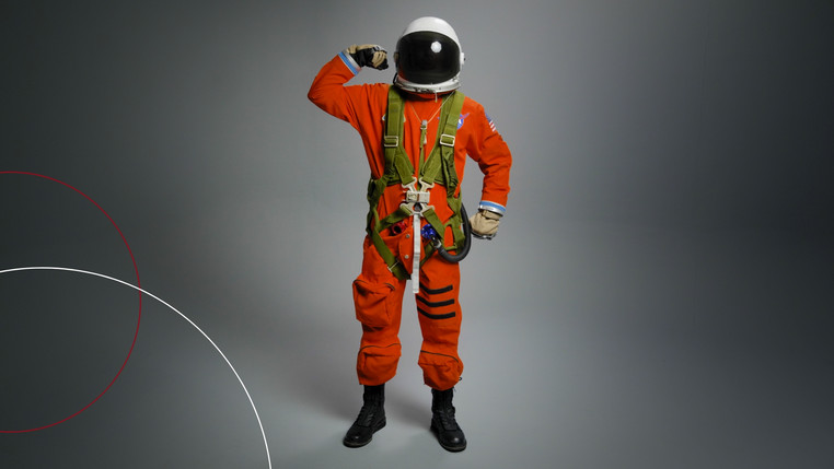 Astronaut mit Helm hebt einen Arm