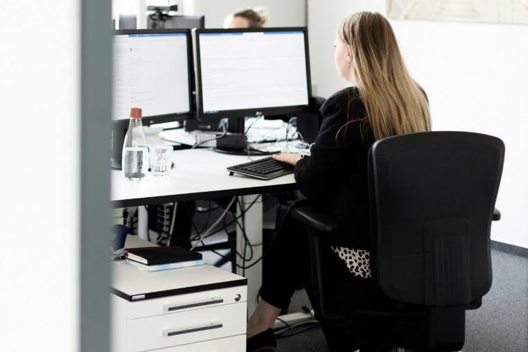 Eine brünette ttplerin sitzt im Büro