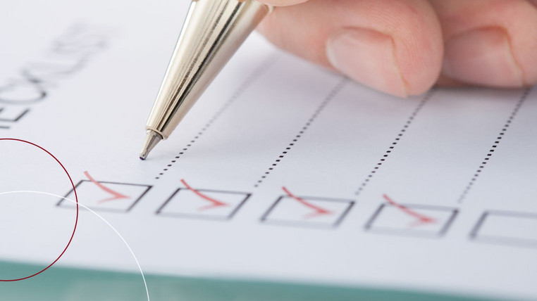 Ein Stift, der eine Checkliste abhakt.