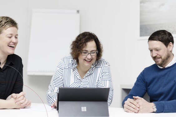 Kollegen sitzen um ein Tablet