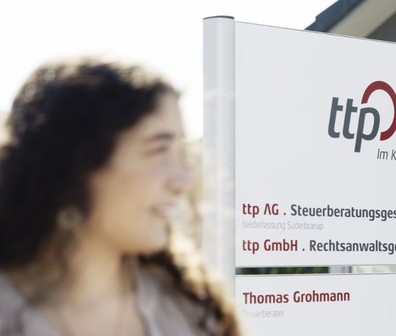 Rechteckiges Bild von zwei ttplern vor einem ttp Standort