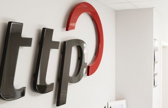 ttp Logo an einer weißen Wand