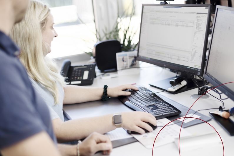Zwei ttp-Mitarbeiter am Arbeitsplatz vor zwei Bildschirmen