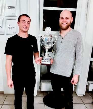 Zwei Männer halten einen Pokal