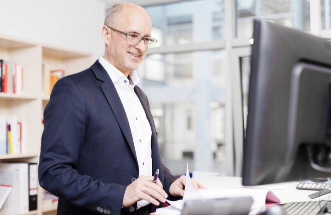Thomas Bertram tippt auf dem Computer