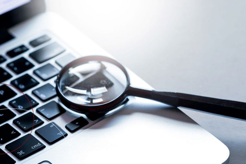 Vergrößerungslupe liegt auf Notebook-Tastatur