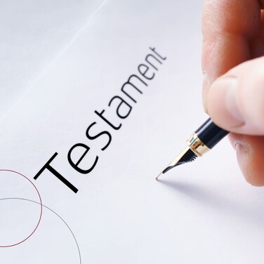 Eine Hand mit Füllfederhalter schreibt ein Testament.