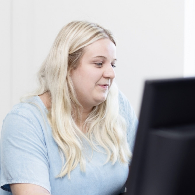 Zwei ttp Mitarbeiter stehen vor einem PC