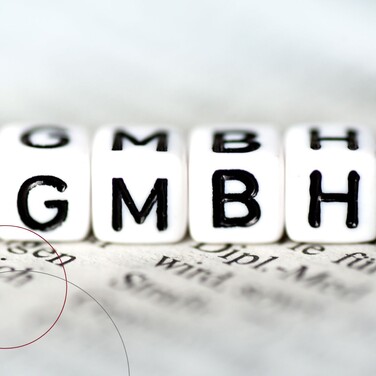 Vier Würfel mit den aufgedruckten Buchstaben "G-M-B-H".